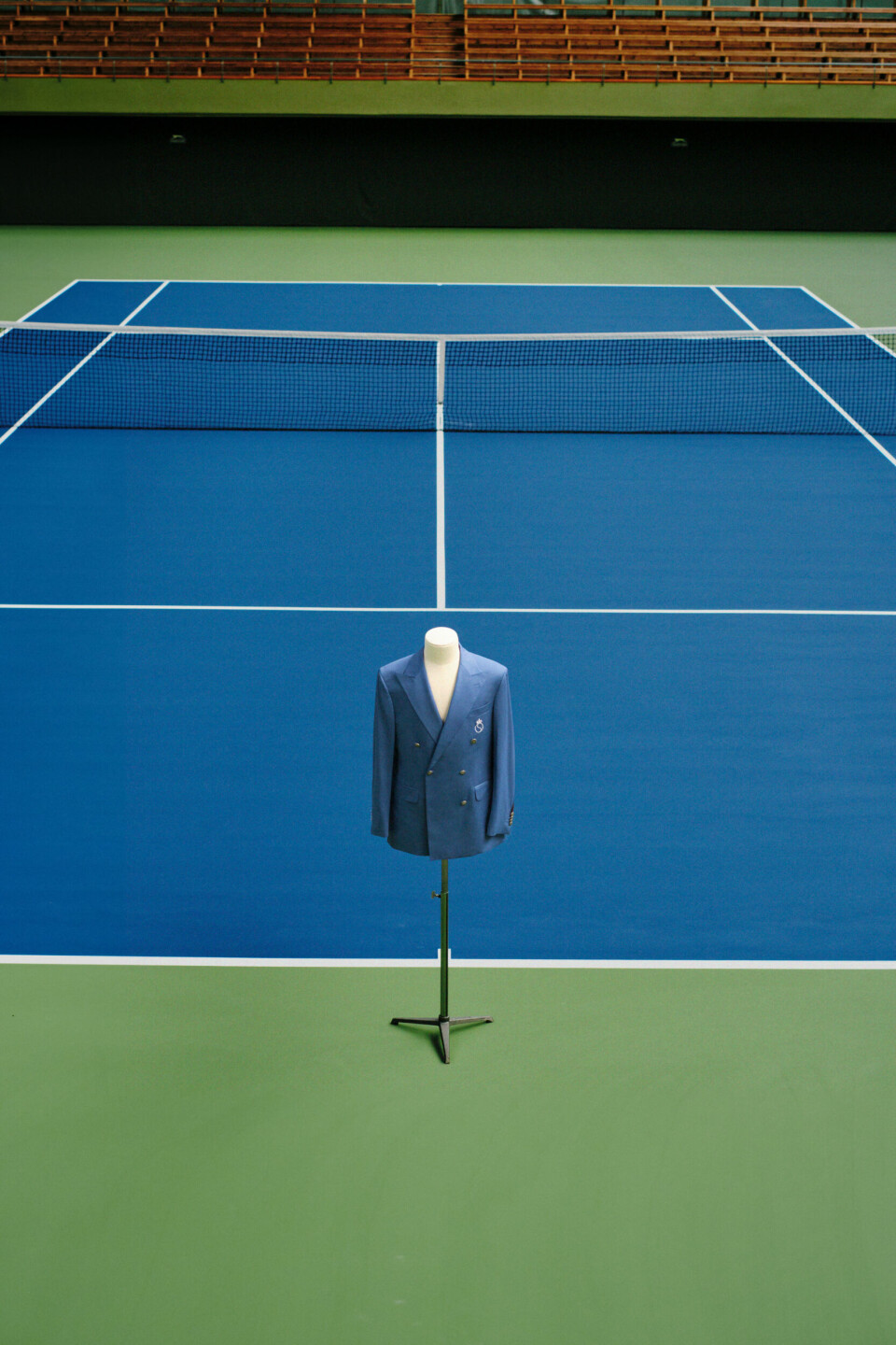 En blå kavaj från Oscar Jacobson står på en ställning mitt på en tennisbana.